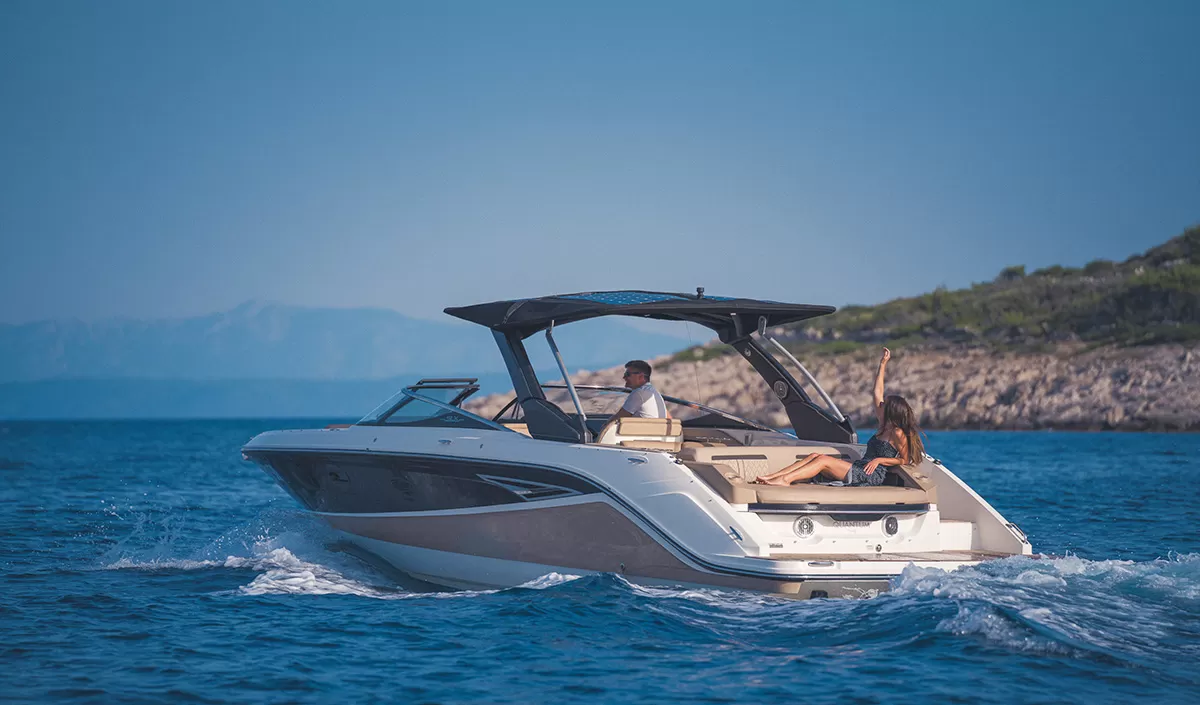 A motorboat on blue water beside the coast